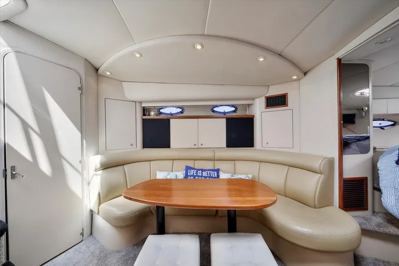 1999 Cruisers Yachts 3870 Esprit interior with curved seating and wooden table.