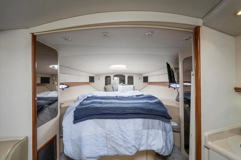 1999 Cruisers Yachts 3870 Esprit cabin interior with bed, mirrors, and cozy lighting.