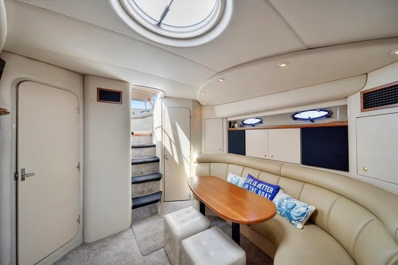 Interior of 1999 Cruisers Yachts 3870 Esprit with seating, table, and stairs.