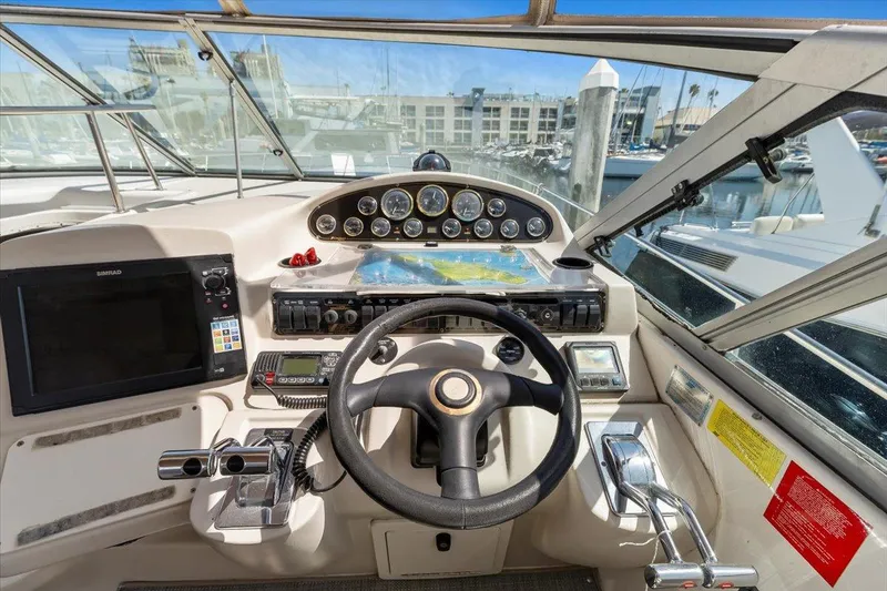 1999 Cruisers Yachts 3870 Esprit helm with steering wheel, gauges, and navigation equipment.