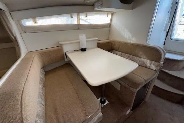 Interior of 2001 Bayliner 2855 Ciera with cozy dining area and beige seating.