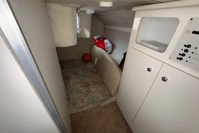 Interior cabin of 2001 Bayliner 2855 Ciera boat, featuring storage and control panel.